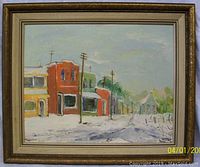 Framed oil painting showing a winter street scene with buildings and telephone poles, signed by artist Terry F.