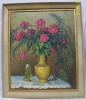 Framed oil painting on board showing a floral arrangement with pink roses in a yellow vase, placed on a white cloth with decorative objects on the table, signed J. Kubarsky.
