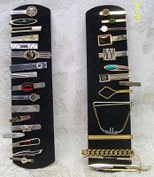 Full view of 31 vintage men's tie clips on two black display boards, showing varied metallic finishes and styles.
