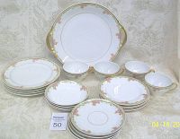 Full set with all cups, saucers, plates, bowls, and serving tray arranged on fabric background