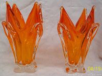 Pair of orange and clear glass flame vases side by side on white surface for size and design comparison
