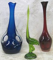 Photo showing blue vase with double handles, red vase, and green bird figurine side by side