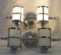 Front view of both twin light chrome and glass wall sconces illuminated