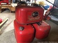 Three red metal gas containers stacked in garage