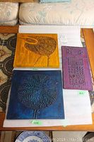 Overview of all three ceramic wall art pieces placed on table showing scale and colors