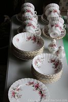 Overview of stacked teacups, saucers, bowls, plates, and salt & pepper shakers arranged on table