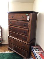 Front view of five-drawer highboy dresser showing brass bail handles and bracket feet