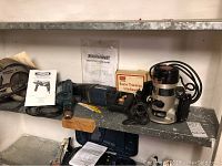 Photo showing the Craftsman router, Mastercraft reciprocating saw, router trimming attachment and accompanying manuals on shelf.