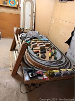 Overview of wooden 4'x10' layout table with track loops and assorted cars.