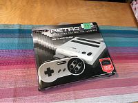 Packaged Retro-Bit Retro Duo console with one controller visible on front of box