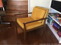 Front view of lounge chair showing wood frame and cushions