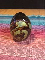 Single four-inch tall signed art glass paperweight with abstract brown and greenish-gold swirls inside clear glass.