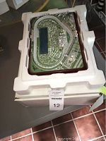 Top view of Daytona International Speedway model in styrofoam packaging, showing detailed racetrack and surrounding areas.