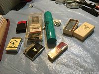 Photo showing various vintage lighters and matchbooks on a blue surface