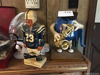 Overview of the three items including Baltimore Colts figurine, football candy dispenser, and blue M&M saxophone character.