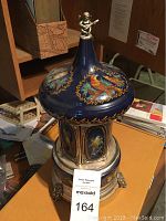 Music box showing top and detailed painting including bird motif.