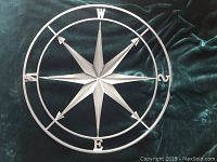 Full view of 28 inch diameter metal star compass with outer direction markers and star center