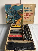 Top view showing train components in original box compartments including locomotive, cars, and metal curved track pieces.
