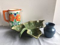 Photo shows 3 pottery items: Hall leaf dish in green, Bern floral pitcher with orange handle, and a small blue glaze vase.