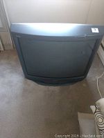 Full front and top view of the Sony Trinitron 32 inch CRT television on carpeted floor.