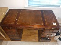 Top view of the antique wooden desk showing the worn dark wood surface and multiple drawers.