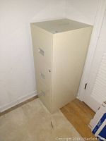 Side and front view of tan metal 3-drawer file cabinet.