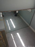 Mirror laying flat on floor showing clear and reflective surface with light reflections