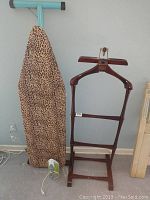 Wood valet stand, ironing board with cheetah print cover, and Black and Decker iron visible in the photo