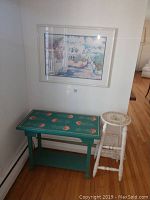 Three-piece lot with white floral stool, blue floral top table, and wall art above them.
