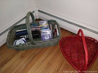 View showing large green wicker basket with assorted CDs and two smaller empty wicker baskets, one red heart-shaped and one green rectangular.