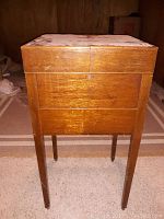Photo showing the front of the antique wooden locking bar cabinet with visible keyhole and worn wood finish.