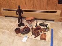 Photo showing all items including wooden drummer figurine, Jaguar hood ornament, wooden bowl, wooden boxes and carved shoes.