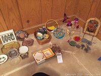 Wide shot of multiple decorative items including stained glass pieces, ceramic boxes, vessel, beaded flowers, and alabaster mushroom