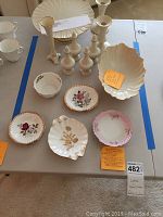 Overview of Lenox and bone china small dishes and candlesticks arranged on a table.