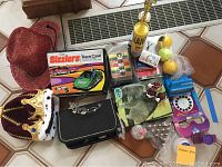 Wide view of assorted toys and games including red cowboy hat, royal crown, Sizzlers Race Case box, puzzle, tennis balls, Viewmaster, bubble solution, and checkers game pieces.