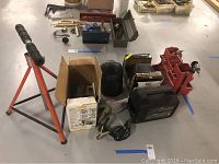 Photo showing the Mity Mite Arc Welder, roller outfeed stand, welding gloves, toolbox and welding helmets.
