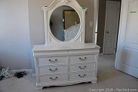 Front view of entire white dresser with attached oval mirror