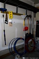 Full view of lot showing tools hung on wall and coils of tubing and wire on floor