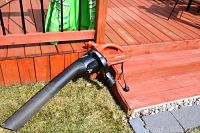 Full side view showing the orange blower unit with attached long black tube and vacuum bag.