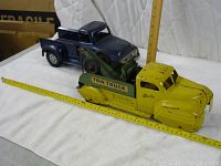 Front angle view of both trucks on white background with measuring tape