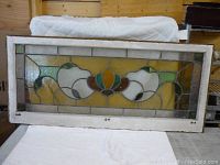 Full front view of leaded glass window pane in white wooden frame