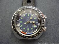 Close-up front face of Mortima wristwatch showing dial, tachymeter bezel, and two crowns.