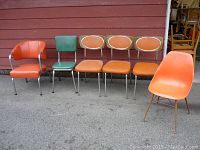 All six chairs lined up outdoors against red siding