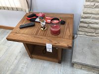 Small pine wood end table with a natural wood finish and some wear. Square top and open base shelf. Items on table not included.