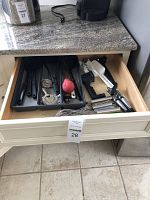 Drawer with kitchen tools including can opener, utensils, peelers, whisks, and spatulas