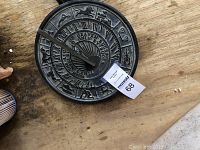 Top down photo of the ornate sundial showing zodiac signs and inscription details