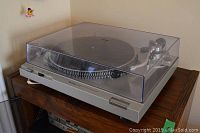 Front-angle view of turntable with closed clear dust cover