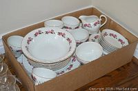 Full overview of the Ridgeway china dinnerware set packed in a box showing plates, bowls, teacups, saucers, creamer and sugar bowl with a pink rose pattern and gold trim.