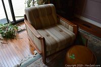 Wide shot showing armchair and ottoman in room setting