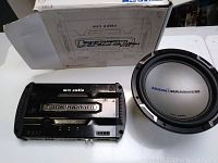 Photo of MTX Audio Jackhammer car amplifier and subwoofer next to original box on white background.